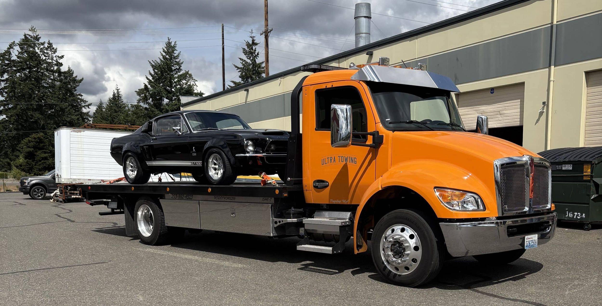 Ultra Towing truck on a road side assistance mission for a red sedan.