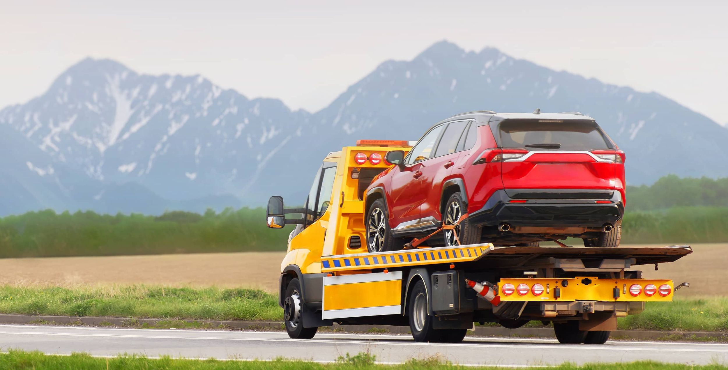 Ultra Towing truck on a road side assistance mission for a red sedan.